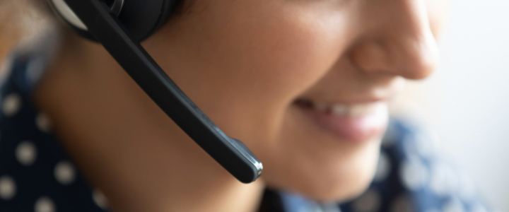 A close-up of a female telesales agent wearing a wireless headset