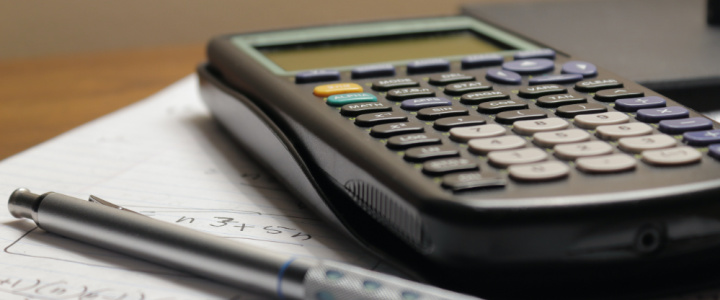 A calculator on a desk with paperwork