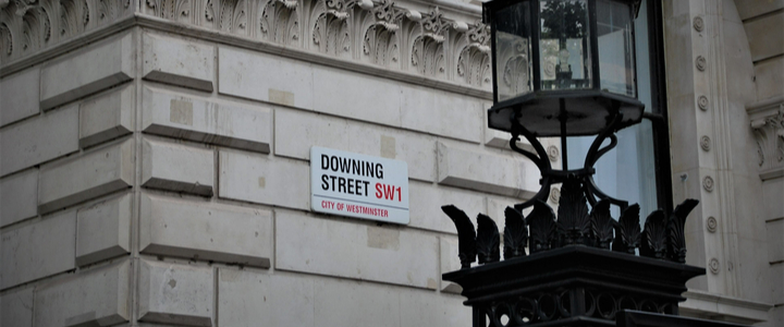 A road sign for Downing Street on the corner of a building