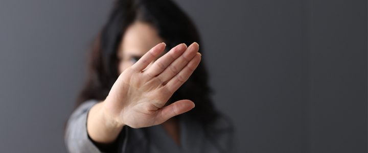 A woman with her held out flat to the camera and covering her face