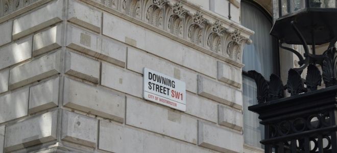 The side of a building with a Downing Street road sign on it