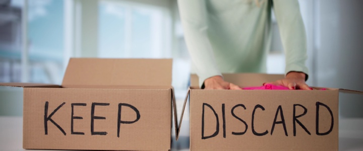 Woman placing items into keep and discard boxes