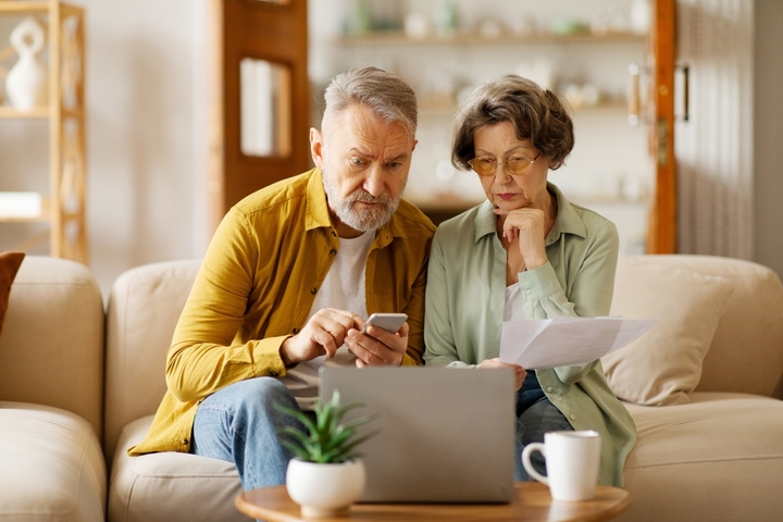 Older couple concentrating on their laptop.