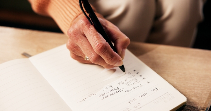Individual writing their to-do list.